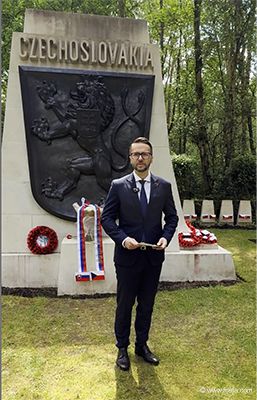Martin Vojtašovič, State Secretary of the Ministry of Defence of the Slovak Republic, standing in front of the Czechoslovak Memorial in Brookwood, with a floral tribute and red carnations.
