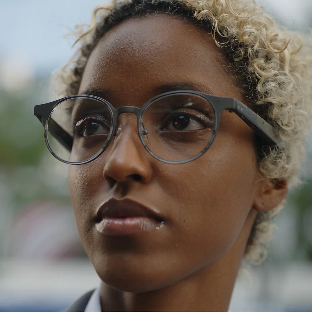  Dymesty camera-free titanium AI glasses worn in a close-up outdoor portrait