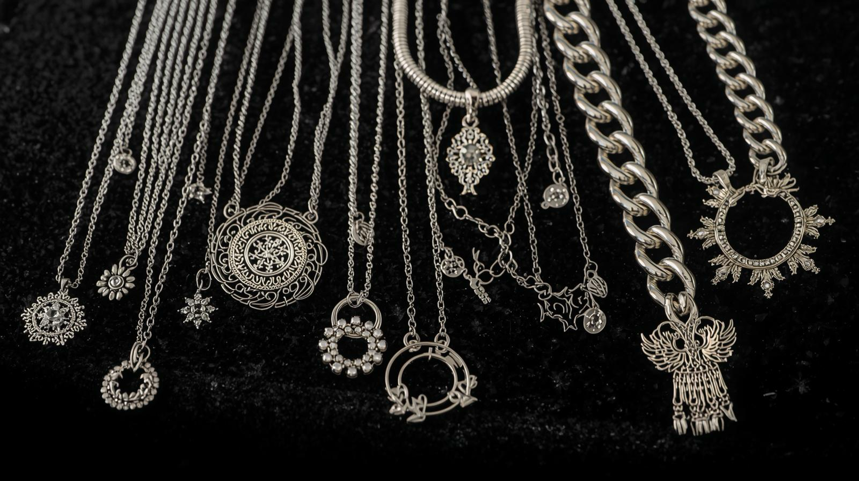 Assorted Silver Necklaces with unique chain and pendant designs displayed on a black velvet surface.