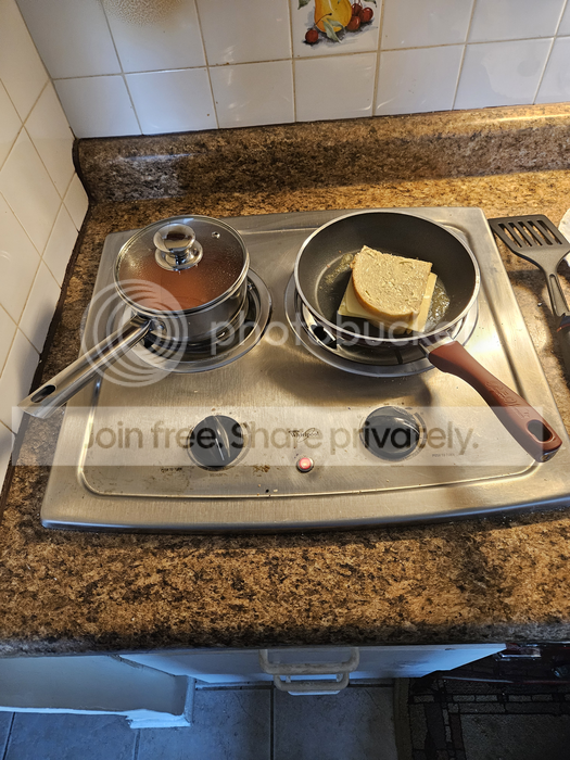 photo of sauce pan and frying pan on electric burners, tomato soup in the sauce pan, and a grilled cheese in the frying pan, with a small red light showing that the burners are energized