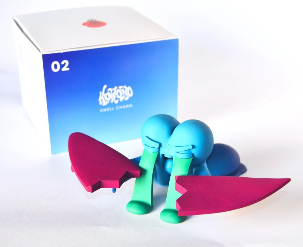 Kokoro Tragedia figure and two piece surfboard beside custom illustrated story box