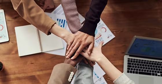 Collega's leggen handen op elkaar