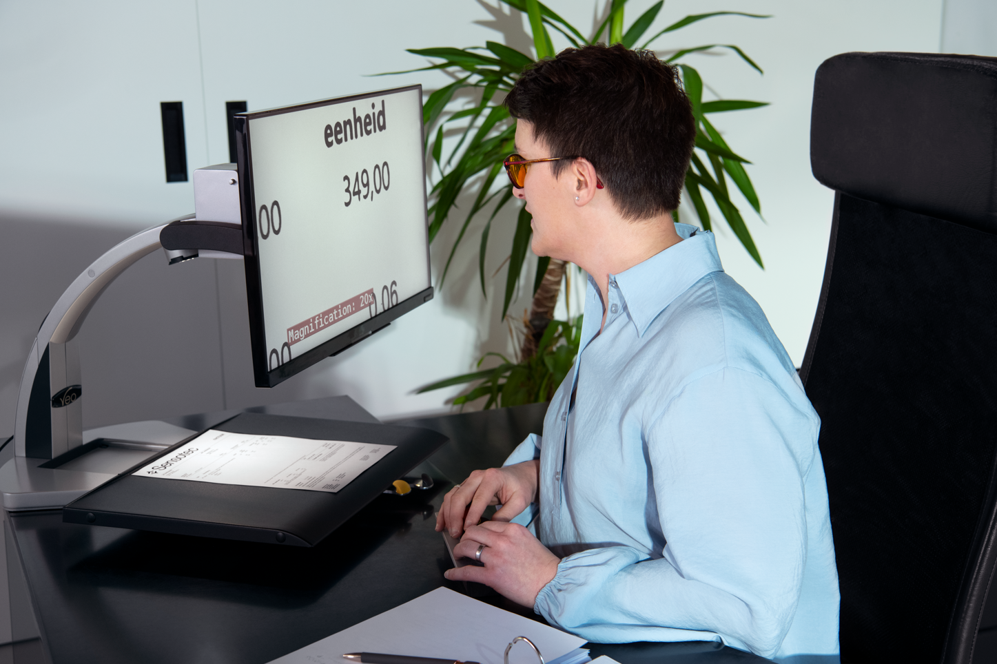 Une femme utilise une loupe d'écran au bureau