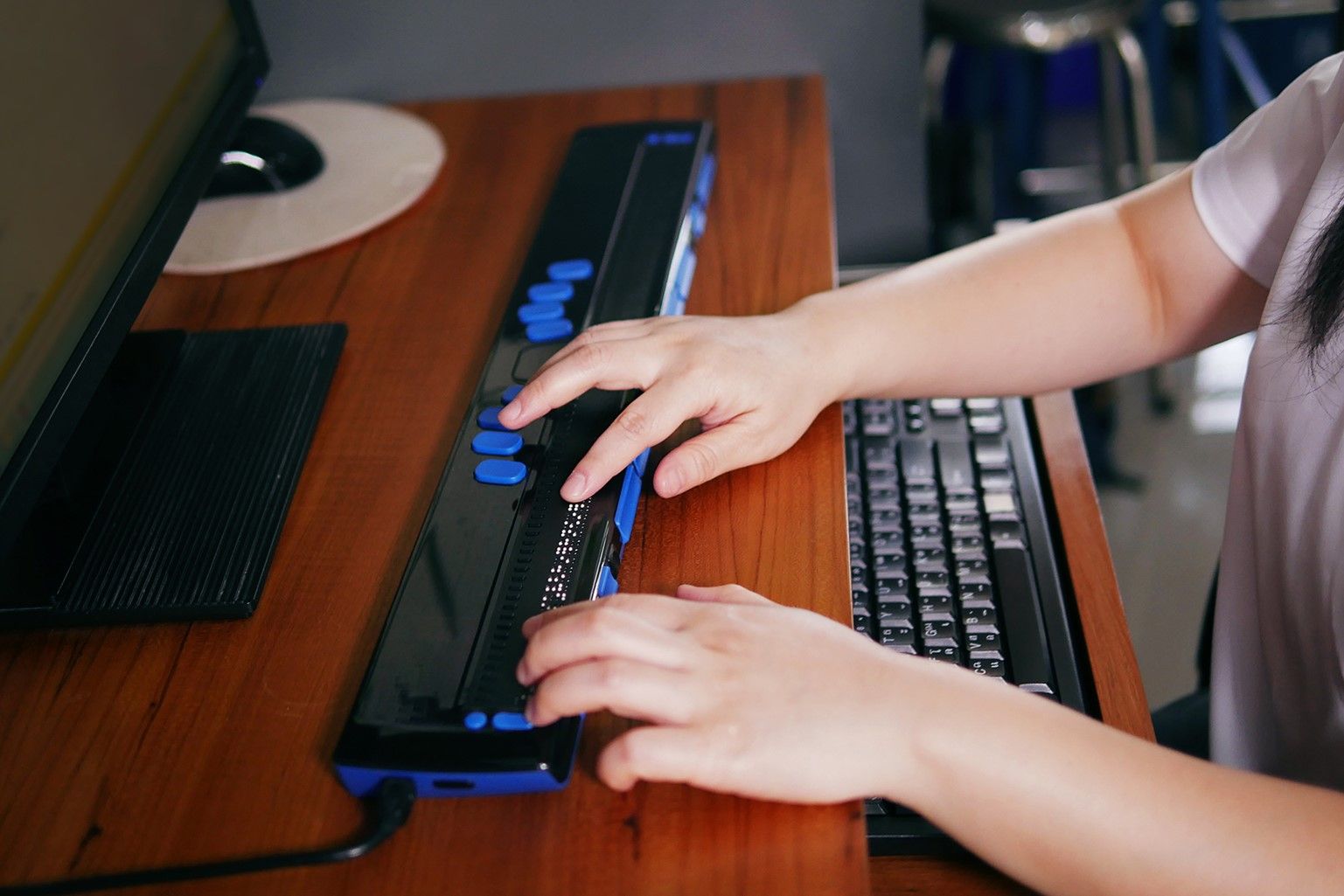 Une femme utilise une barrette braille Focus Blue 80