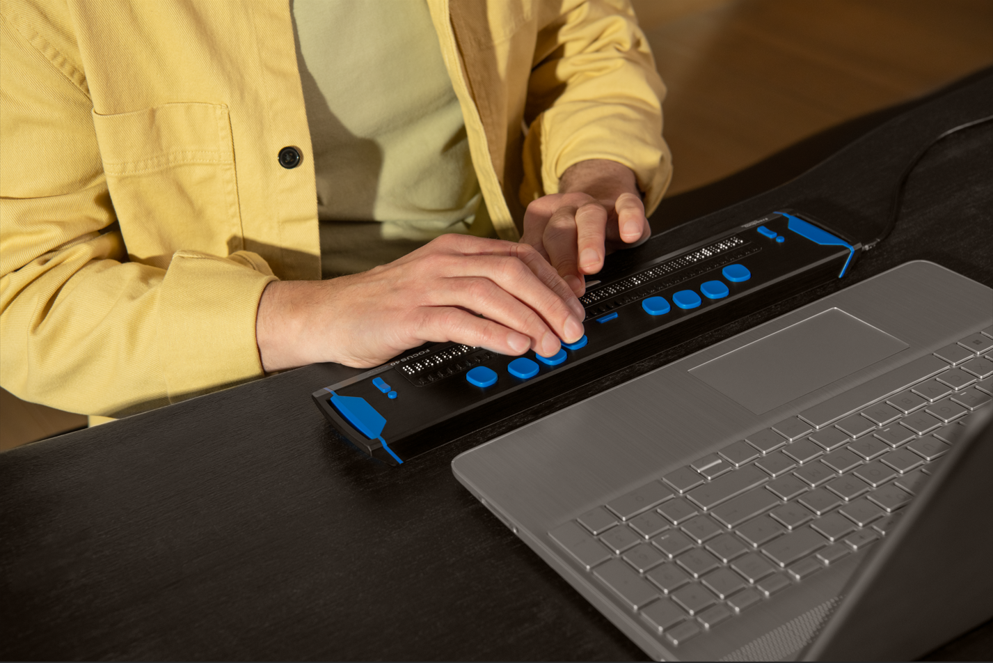 Un homme utilise un afficheur braille au bureau