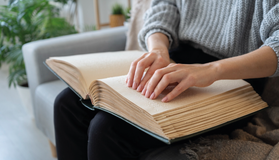 Vrouw leest boek in braille