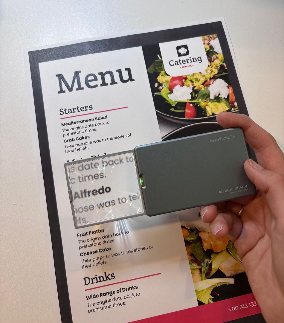 Personne lisant un menu de restaurant grâce à la loupe optique Easypocket