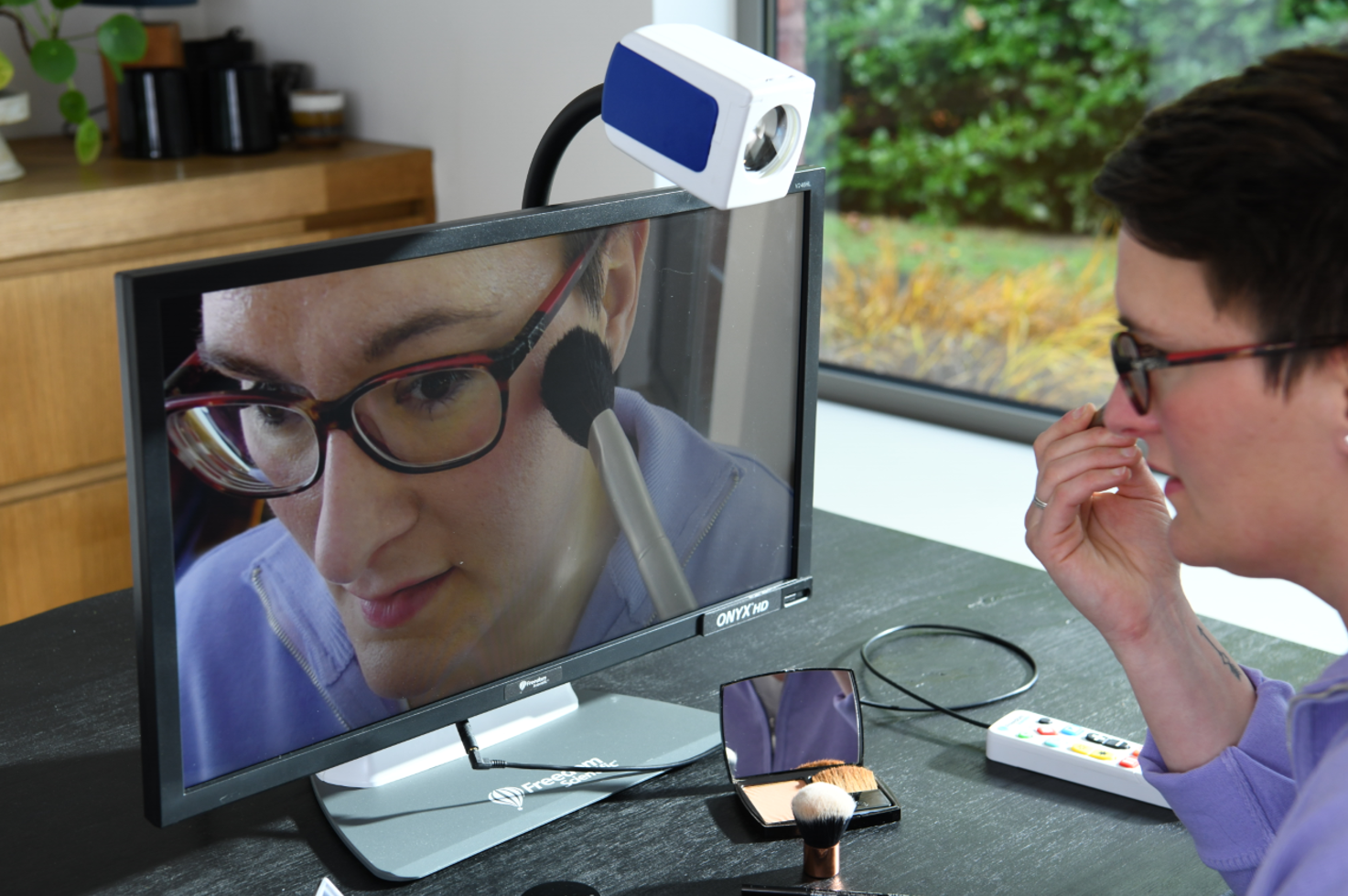 Een vrouw die een Onyx-videoloep gebruikt om zich op te maken