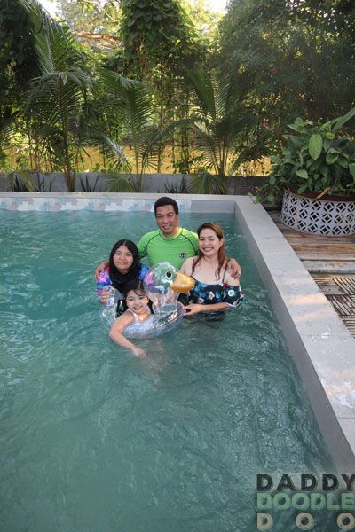 Family enjoying a swim in the main pool at Fabrika villas.