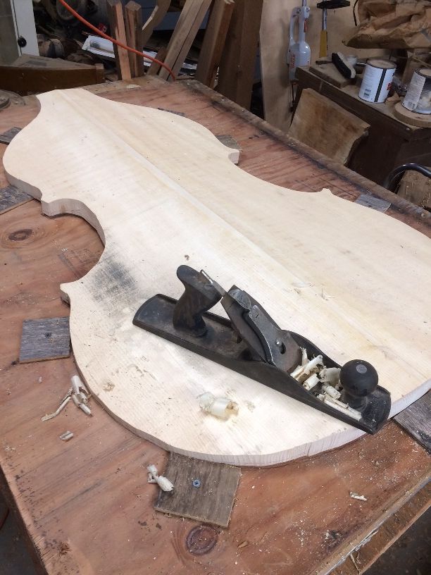 Front plate for the 5-string double bass secured in a work cradle.
