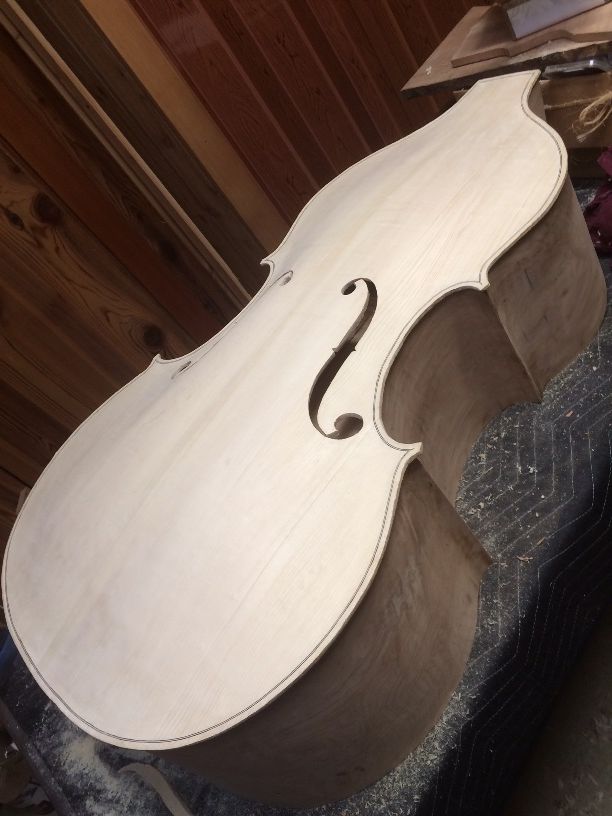 Completed front plate resting on the garland of a five-string double bass.