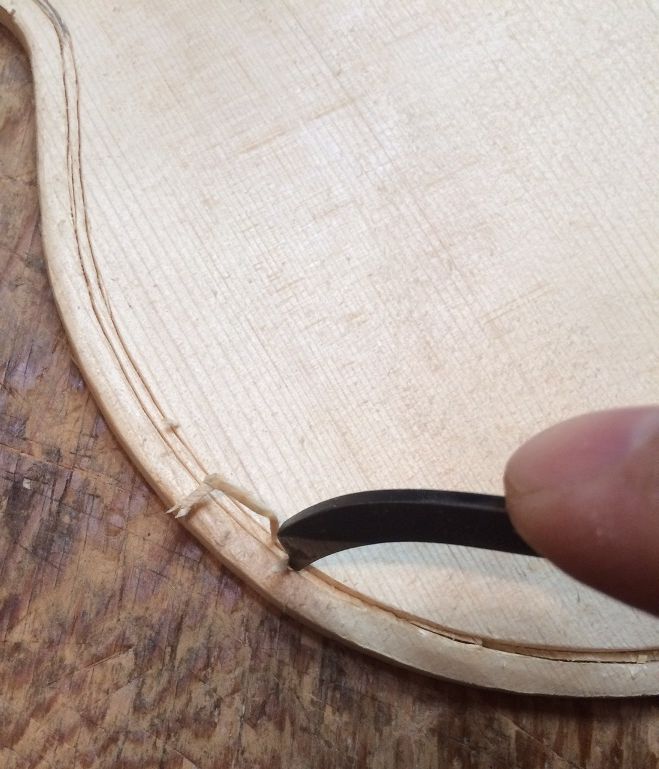 picking waste wood from the purfling slots on a 5-string fiddle handmade in Oregon by Chet Bishop