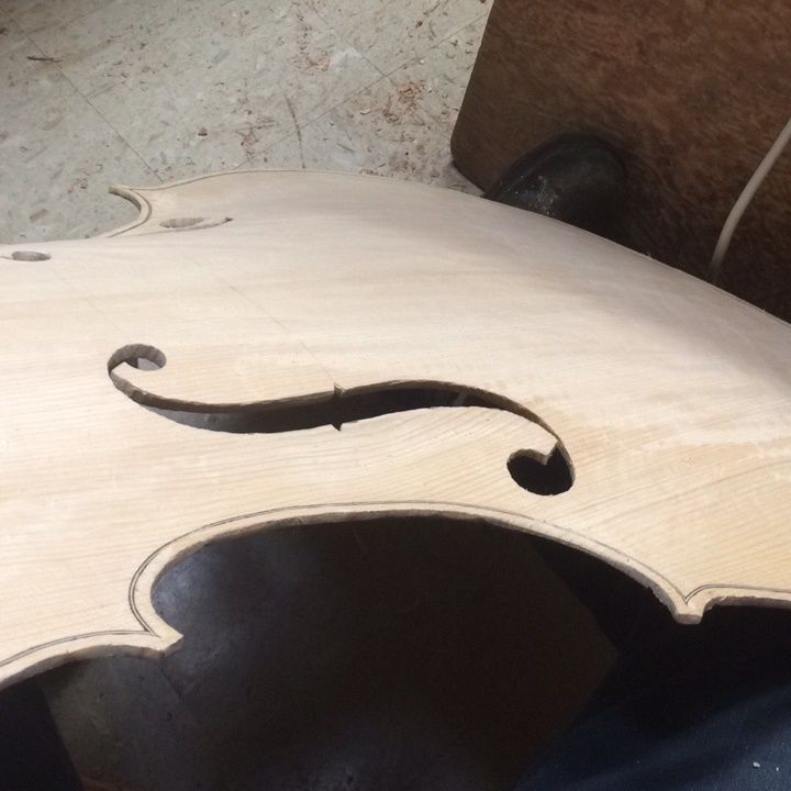 Rough cut f-hole on 5-string double bass ready for refinement.