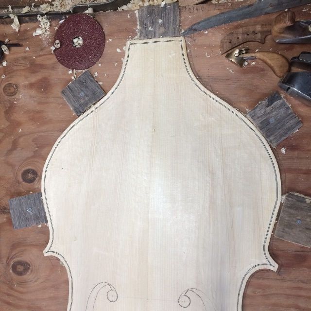 Upper bouts of five-string double bass with purfling installed.