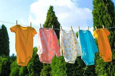 Baby clothes hanging outside on clothesline