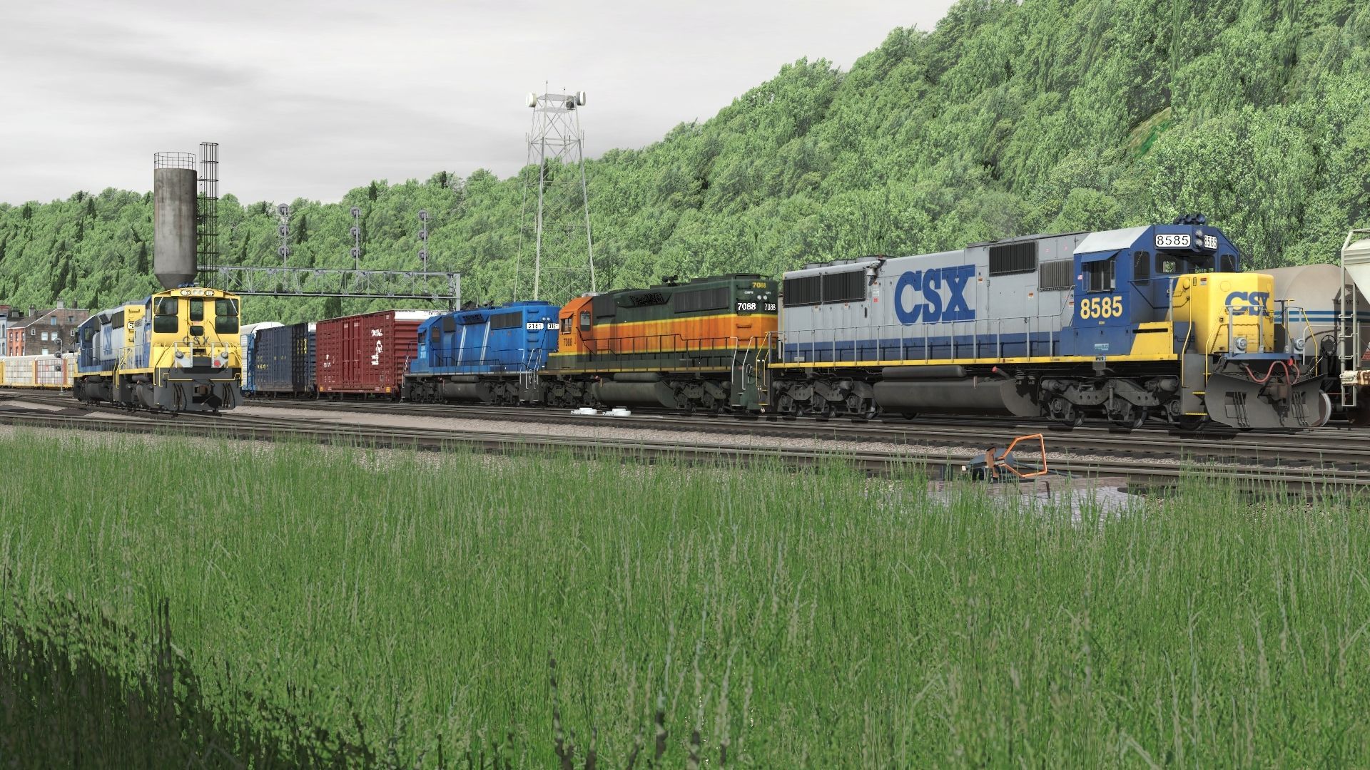 A-CSX-manifest-idles-at-the-yard-with-a-trio-of-EMD's-at-the-point.-To-the-left_-helpers-are-waiting-to-shove-a-northbound-over-the-hill.(1).jpg