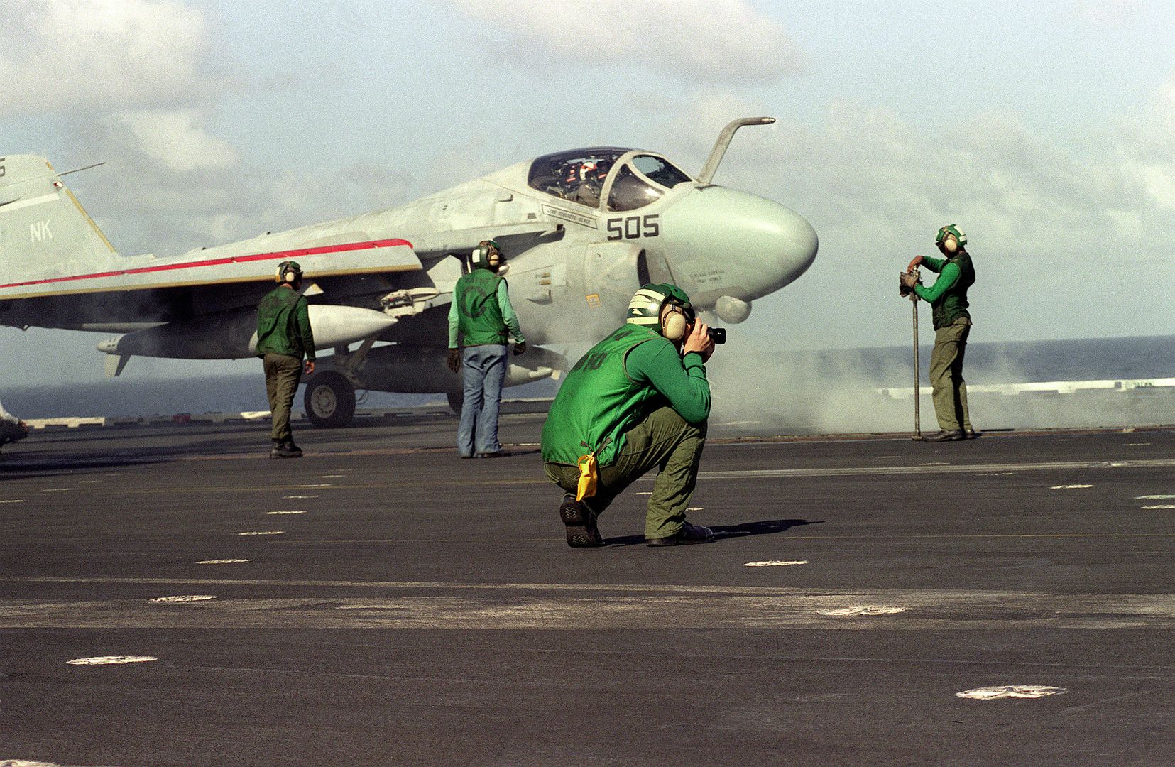 A Crewmember Takes Photographs While An A 6E Intruder Aircraft Prepares To Catapult From The Deckof The Aircraft Carrier USS CONSTELLATION