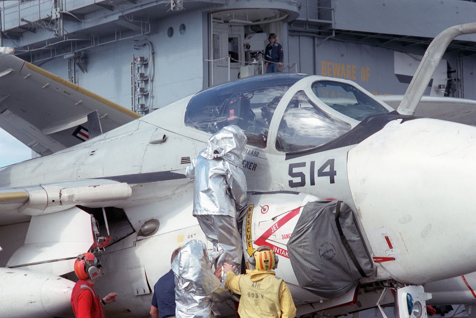 A Firefighter Wearing A Proximity Suit Climbs Onto An A 6E Intruder Aircraft During A General Quarters Drill Aboard The Nuclear Powered Aircraft Carrier USS THEODORE ROOSEVELT