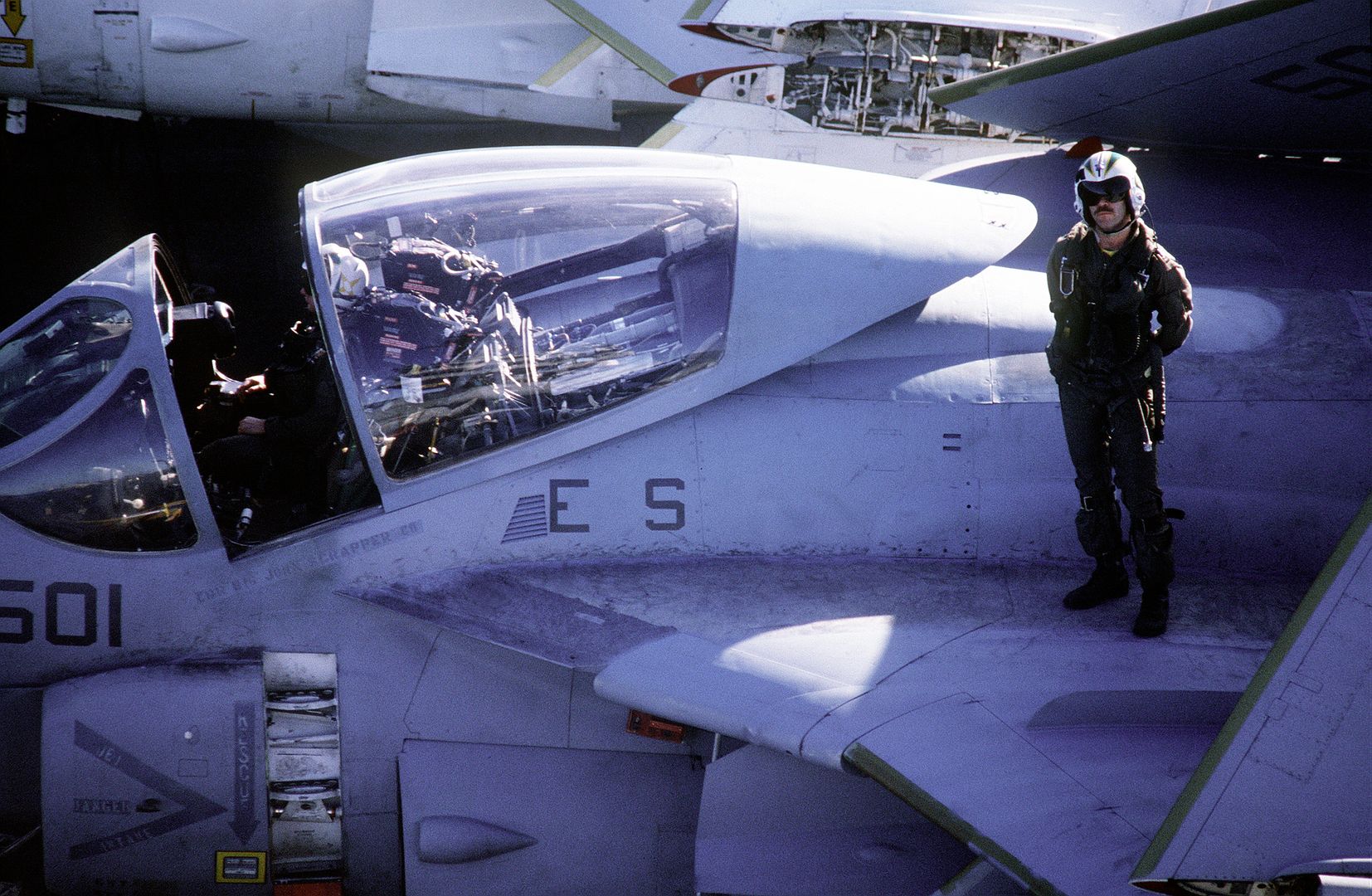 A Pilot Poses For A Photo Next To The Cockpit Of An A 6E Intruder Aircraft Parked On The Flight Deck Of Theaircraft Carrier USS KITTY HAWK