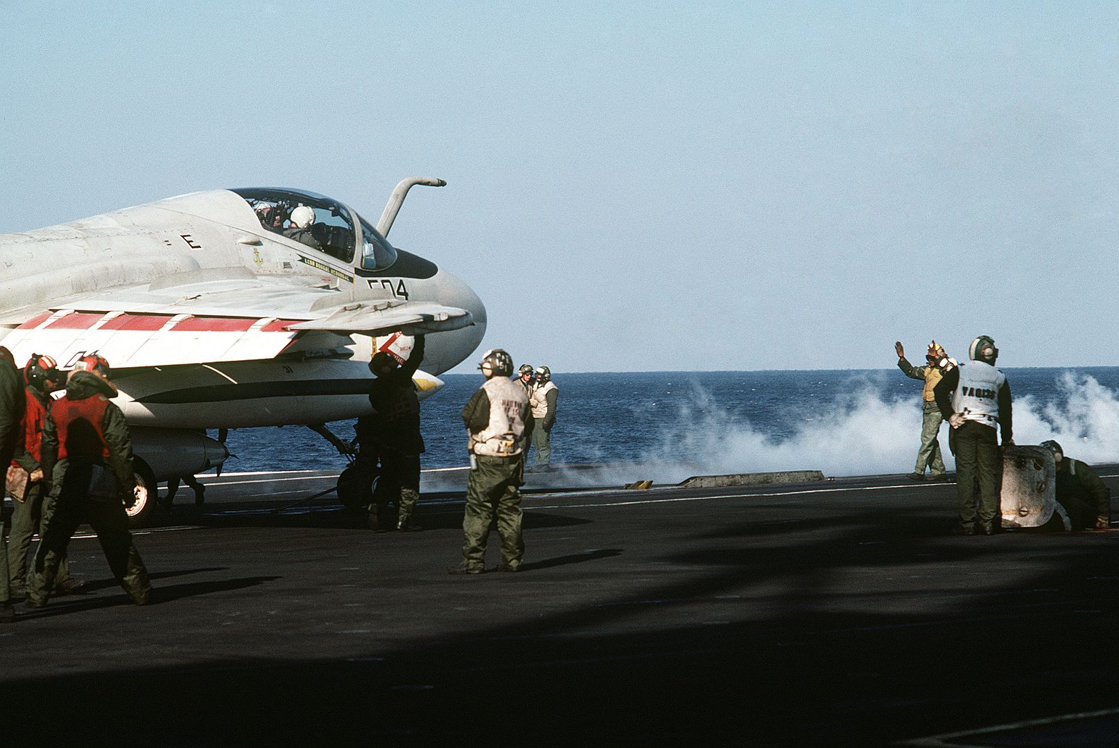 A Plane Director Aboard The Aircraft Carrier USS MIDWAY Guides An A 6E Intruder Aircraft Onto A Catapult