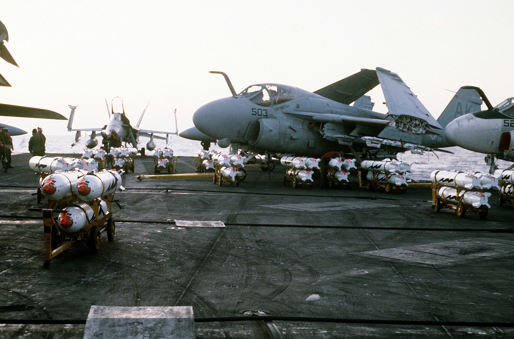 Bomb Skids Loaded With CBU 59 Cluster Bombs Are Staged On The Flight Deck Of The Aircraft Carrier USS CORAL SEA Prior To Being Loaded Aboard A 6E Intruder Aircraft For An Air Strike On Targets In Libya
