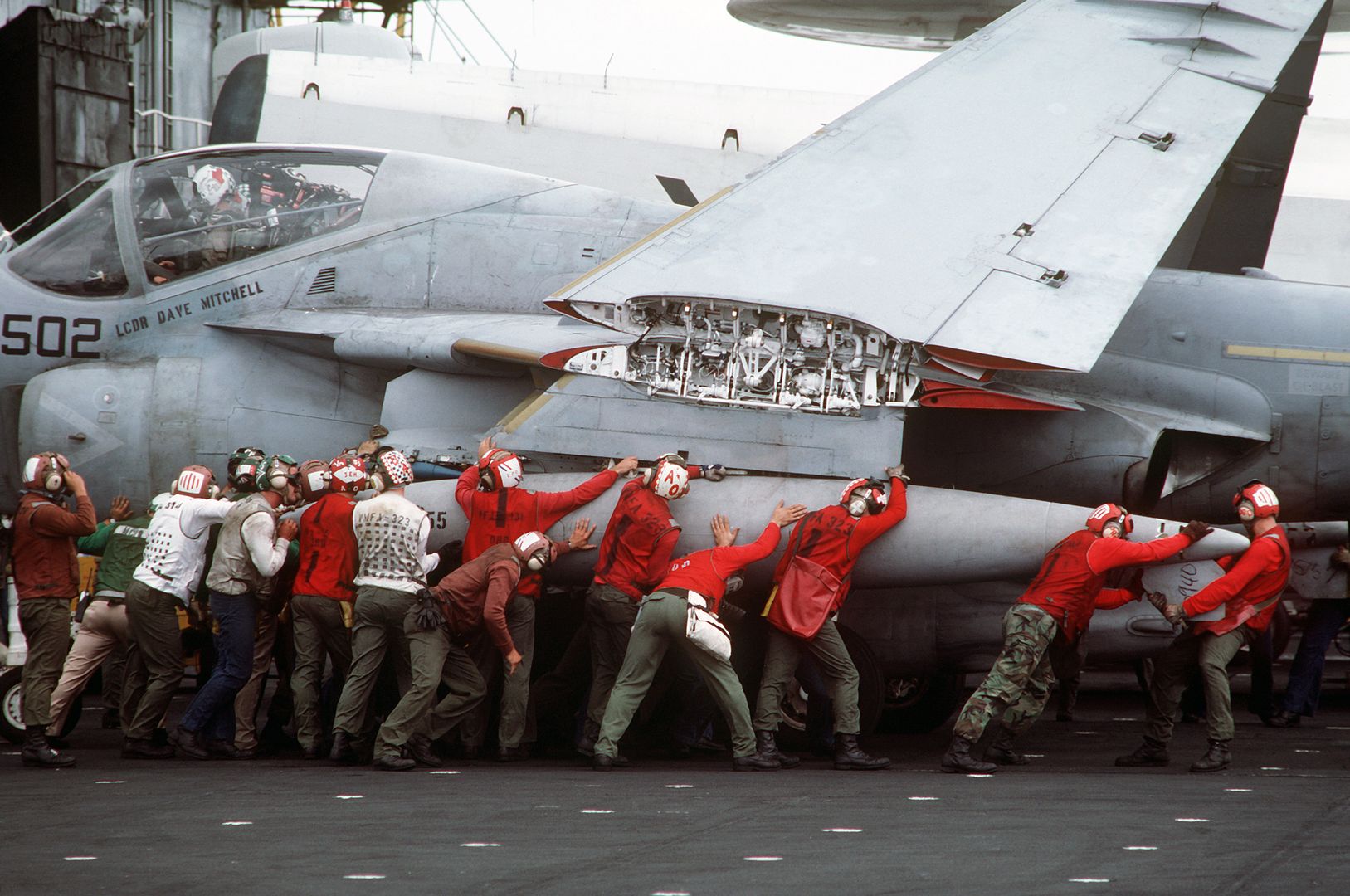 Flight Deck Crewmen Maneuver An A 6E Intruder Aircraft On The Flight Deck Of A US Navy Aircraft Carrier