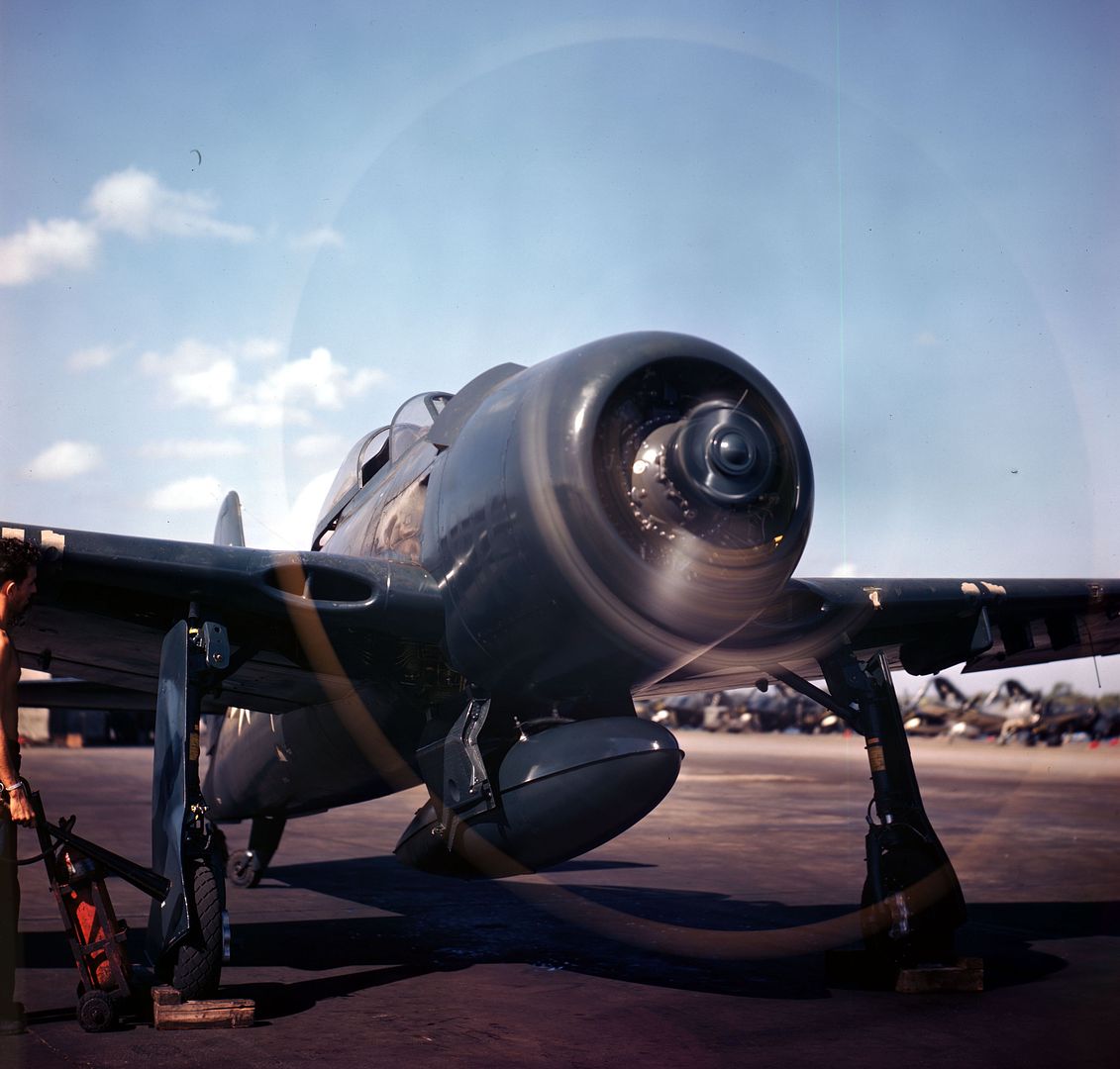 Ground Crewman Stands By With Fire Bottle As Plane Captain Warms Up F8F