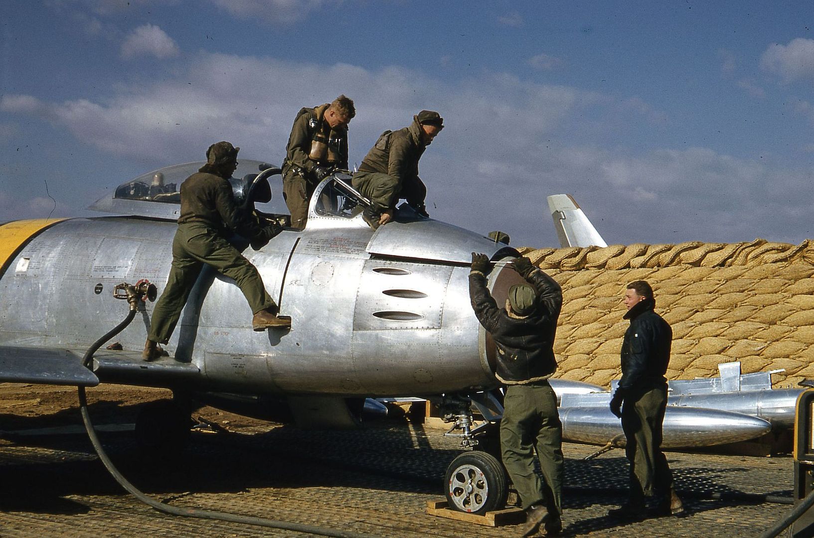 Right_side_view_of_a_North_American_F_86_Sabre._One_technician_watches_as_the_pilot_climbs_out_of_the_cockpit_.jpg