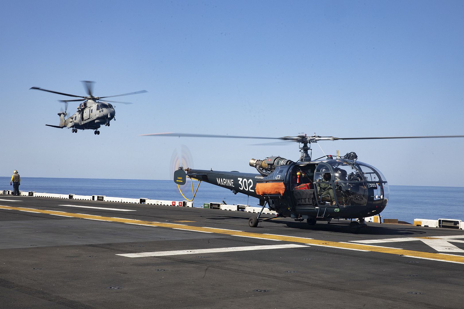 SH101 A Helicopter And A A French Alouette Helicopter Participate In Joint Flight Operations On The Flight Deck Of The Wasp Class Amphibious Assault Ship USS Bataan