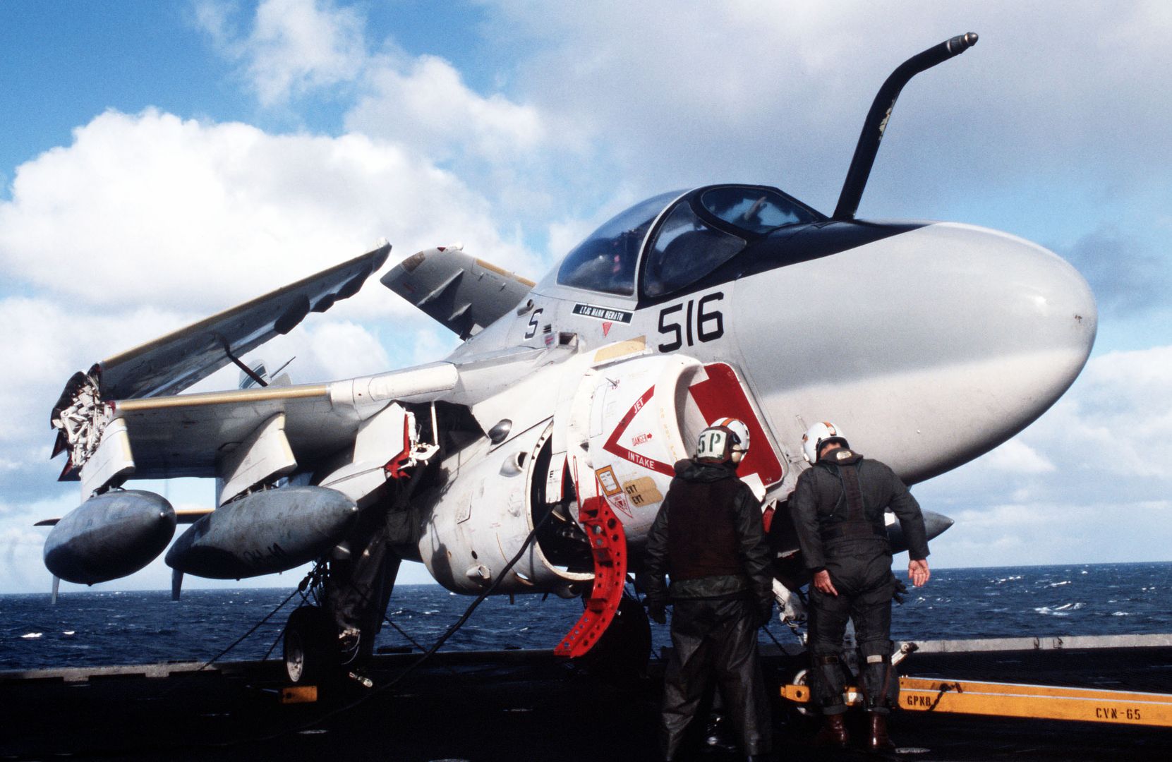 The Pilot And Bombardier Navigator Of An Attack Squadron 95 A 6E Intruder Aircraft Confer With A Maintenance Crewman On The Flight Deck Of The Nuclear Powered Aircraft Carrier USS ENTERPRISE