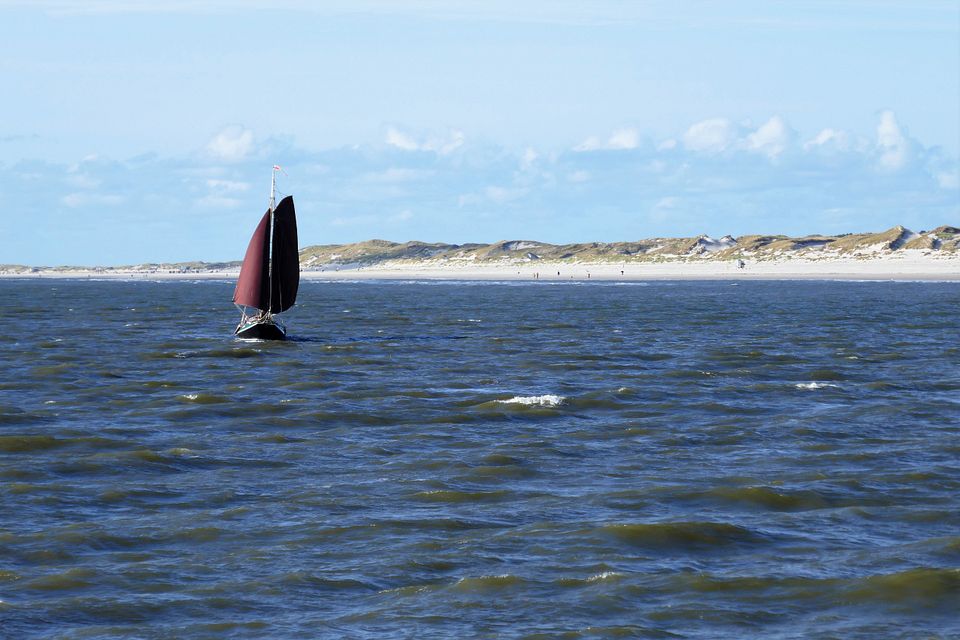Rotes Segelboot und Strand